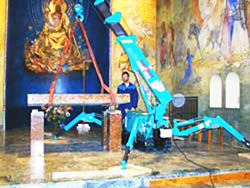 Minikran montiert einen Altar in einer Kirche